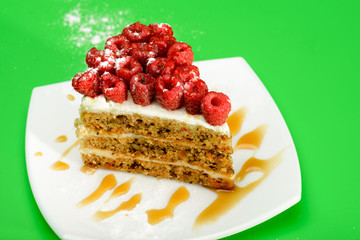 Delicious Raspberry Cake on white plate and green background