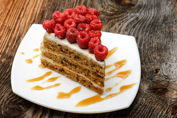 Delicious Raspberry Cake on white plate and wooden background
