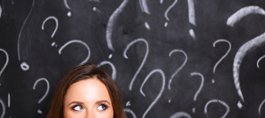 Young girl with question mark on a gray background