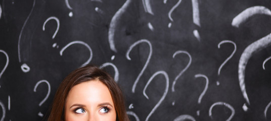 Young girl with question mark on a gray background