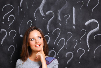 Young girl with question mark on a gray background
