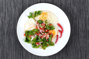 Thai food,Spicy wing bean with pork topped fried egg.