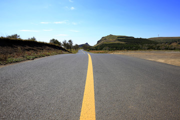 asphalt road on grassland