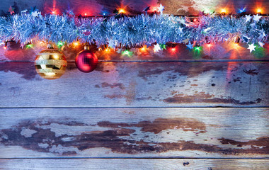 close up view of christmas tree toys and lights on wooden back
