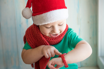 Adorable boy in Santa hat looking time