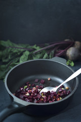 Peaces of red beet in metal dark pan.