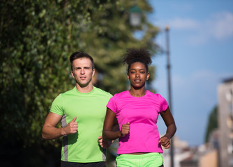 Obraz premium young smiling multiethnic couple jogging in the city