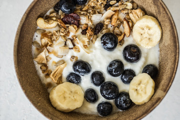 brunch : home made yogurt with granola and banana in wooden bowl.