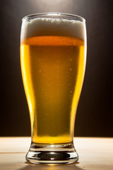 glass of beer shot against a dark background
