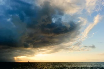 Schilderijen op glas  Ocean Storm Sailboat Sunset Approaching Looming Dramatic Hope Faith Sky © mexitographer