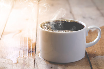 Hot coffee in a white cup on a wooden table.