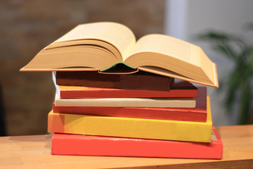 aufgeschlagenes Buch auf einem Bücherstapel
