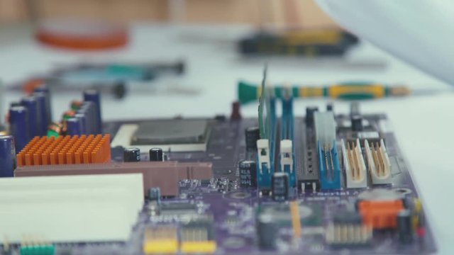 Computer USB port components over motherboard. Printed Circut Board. Stand for chips. Close-up: the motherboard. Hands of the master repair of computer technology and microchips.