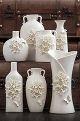 Different Decorative White Vases on Brown Background