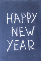 Fototapeta premium Happy New Year written in white chalk on a chalkboard