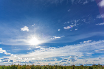 ciel bleu avec nuages et soleil au-dessus de l'horizon