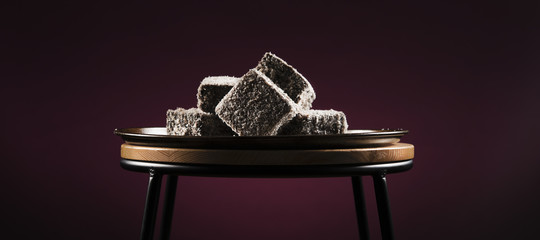 Group of Lamingtons on a metal baking tray.