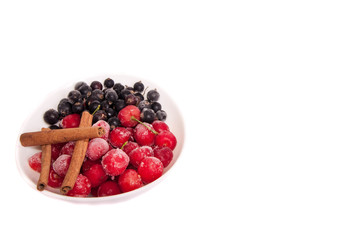 Frozen cherries and currants .cinnamon sticks on white backgroun