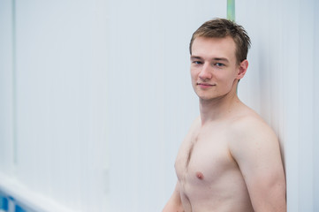 Fototapeta na wymiar Handsome athletic male posing in a swinning pool