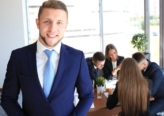 Businessman with colleagues in the background in office