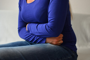 Attraktive Frau mit Bauchschmerzen