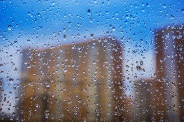 Abstract background. Drops of water on the window. High-rise buildings.