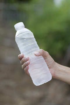 woman holding a bottle of water after fitness