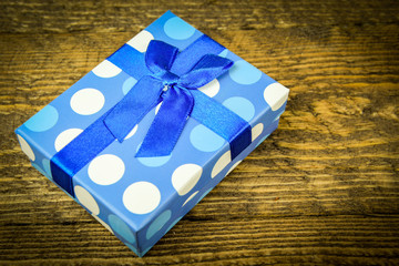 beautiful blue a present with blue beads on a wooden background