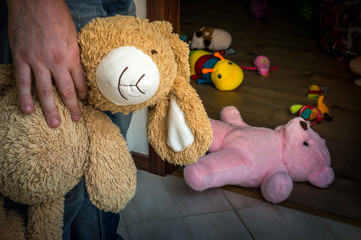 Picture of pedophile standing in the child room with cuddly toy