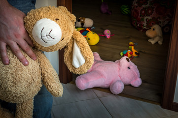 Picture of pedophile standing in the child room with cuddly toy