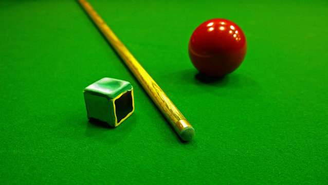 Cue, chalk and snooker ball are on the table