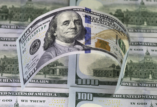 Row of hundred us  dollars bills standing on hundred usa dollars banknotes background.