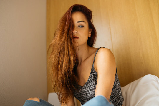 Fototapeta Young beautiful woman sitting on bed
