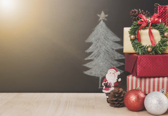 Christmas table with decorations and gift box on christmas tree background.