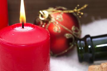 Christmas card with candles and bottle of champagne in the snow