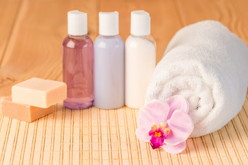 Obraz na płótnie Canvas Bottled cosmetics and towel for spa closeup