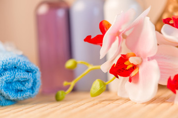closeup of orchid flowers and bottles of cosmetics for spa