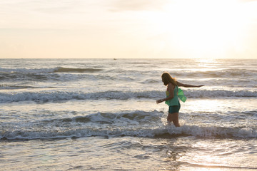 Fototapeta na wymiar woman walking on the sand beach, sunshine in the morning