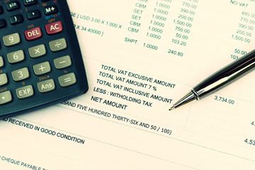 Data analyzing and tax with calculator and pen.