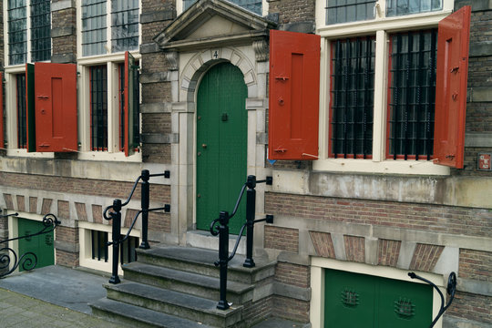 facade of the house with the green door and red shutters