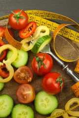 Mixed vegetables on a fork. Diet concept. The risk of obesity. Fresh food diet. Raw vegetables on a black table.
