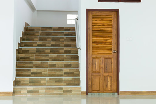 white empty room interior with wooden door and staircase
