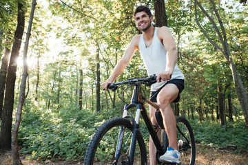 Fototapeta premium Smiling cyclist in forest