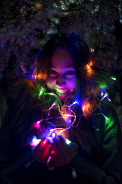 Young smiley girl holding lighting chain