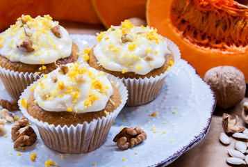 pumpkin cupcakes with cream and pumpkin on a table
