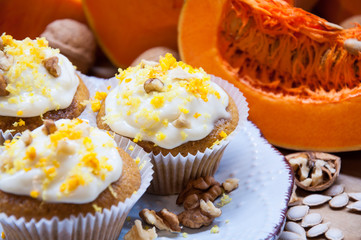 pumpkin cupcakes with cream and pumpkin on a table
