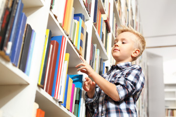 Biblioteka. Chłopiec wybiera książkę 