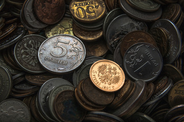 old gold coin of the end of the nineteenth century against the background of coins of small cost