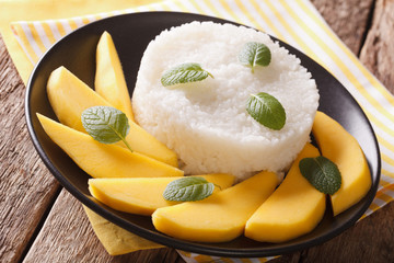 Glutinous rice with ripe mango close-up te on the table. Horizontal