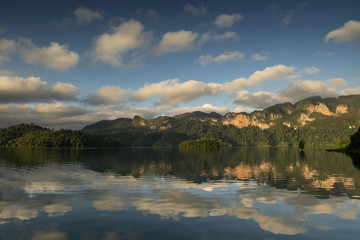 Fototapeta premium View of mountain and cloud in Khao Sok National Park, ratchaprapha dam Suratthani Thailand. Rock mountain with cloudy reflected on lake.